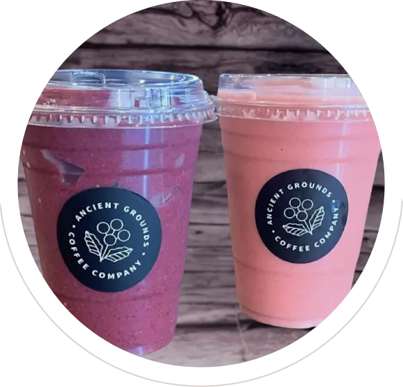 Two colorful smoothies in plastic cups.